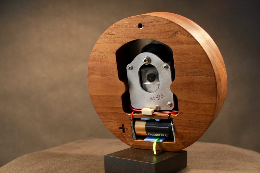 The rear view of the moon clock, showing a modified 24-hour quartz movement connected to the 57:58:59 tooth wheel set from a tide clock that provides the lunar day when run at half speed. The piece rests on a magnetic base. 